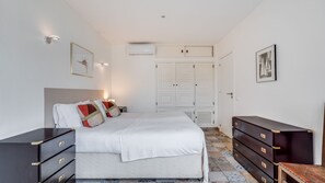 Une chambre à coucher comprenant un lit, une commode, une armoire et une table de chevet.