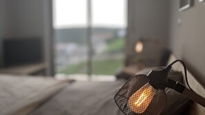 A close-up of a textured light fixture with a glowing bulb, mounted on a wall with a window in the background. - Sesimbra 3BDR Apartment W/Terrace by LovelyStay (Castelo)