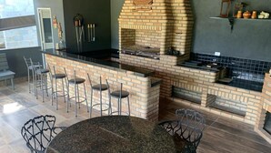 Una cocina con horno de ladrillo, barra y asientos.