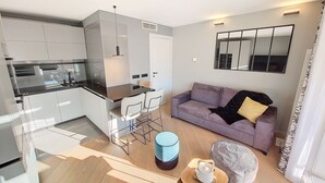 En moderne lejlighed med køkken, spiseområde og opholdsstue.