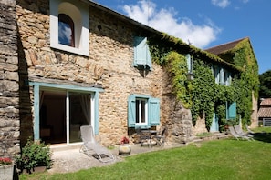 Experience a traditional stay in this historic building with a rustic charm, featuring a large front door and covered patio with seating area.