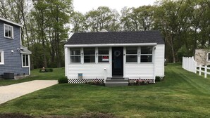 Une petite maison de plain-pied, avec un porche à l’avant, une pancarte « À louer » et une boîte aux lettres.