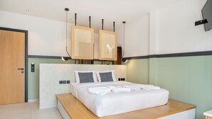A modern bedroom with a large bed, wooden headboard, and built-in shelves. - Casa di Cornaro (Sitia)