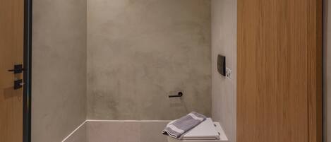 Un baño moderno con bañera, inodoro y un cubo de basura.