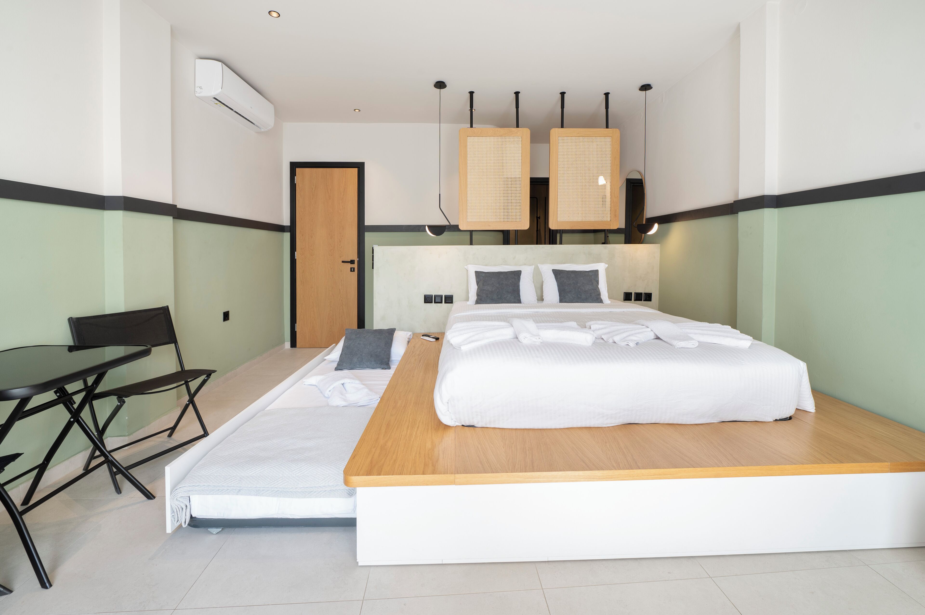 A modern hotel room with a bed, a desk, and a chair.