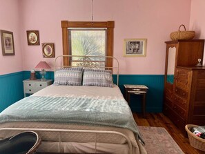 A bedroom with a bed, a nightstand, a dresser, and a window with blinds. - Top of the Stairs Old Bisbee|Park & Walk to Main Street (Bisbee)