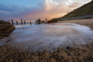 Enjoy the serene coastal scenery with a rocky shoreline and wooden posts extending into the water.