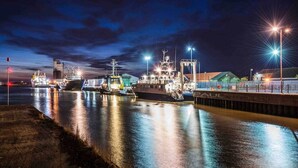 A nighttime harbor scene with boats docked, a pier, and industrial structures. - Luxurious Victorian Home by the sea - Myana House (Lowestoft)