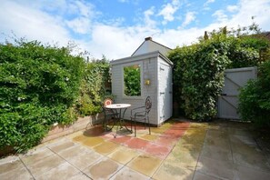 Enjoy a peaceful retreat in this serene garden patio featuring a charming gazebo and comfortable outdoor seating.