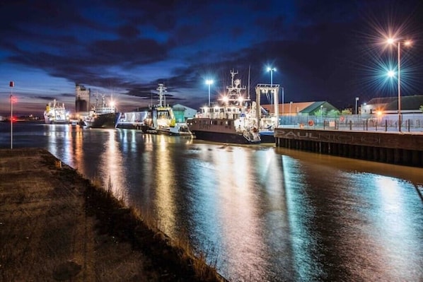 Stunning harbor views from the pier, where ships dock and reflect off the calm water.