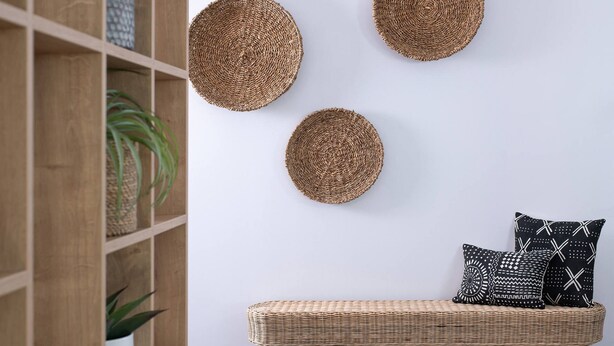 A room with a woven wall hanging, a bench, and patterned cushions. - Infinite Blue Apartments (Malevizi)
