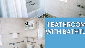 A bathroom with a bathtub, toilet, sink, and handrails.