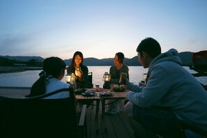Guests enjoy a lakeside meal together on the deck.