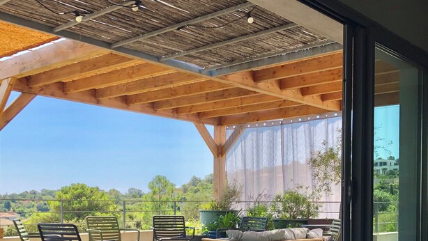 A covered outdoor seating area with chairs and a table, overlooking a scenic landscape. - Beachfront family home for 14 people (Zonza)