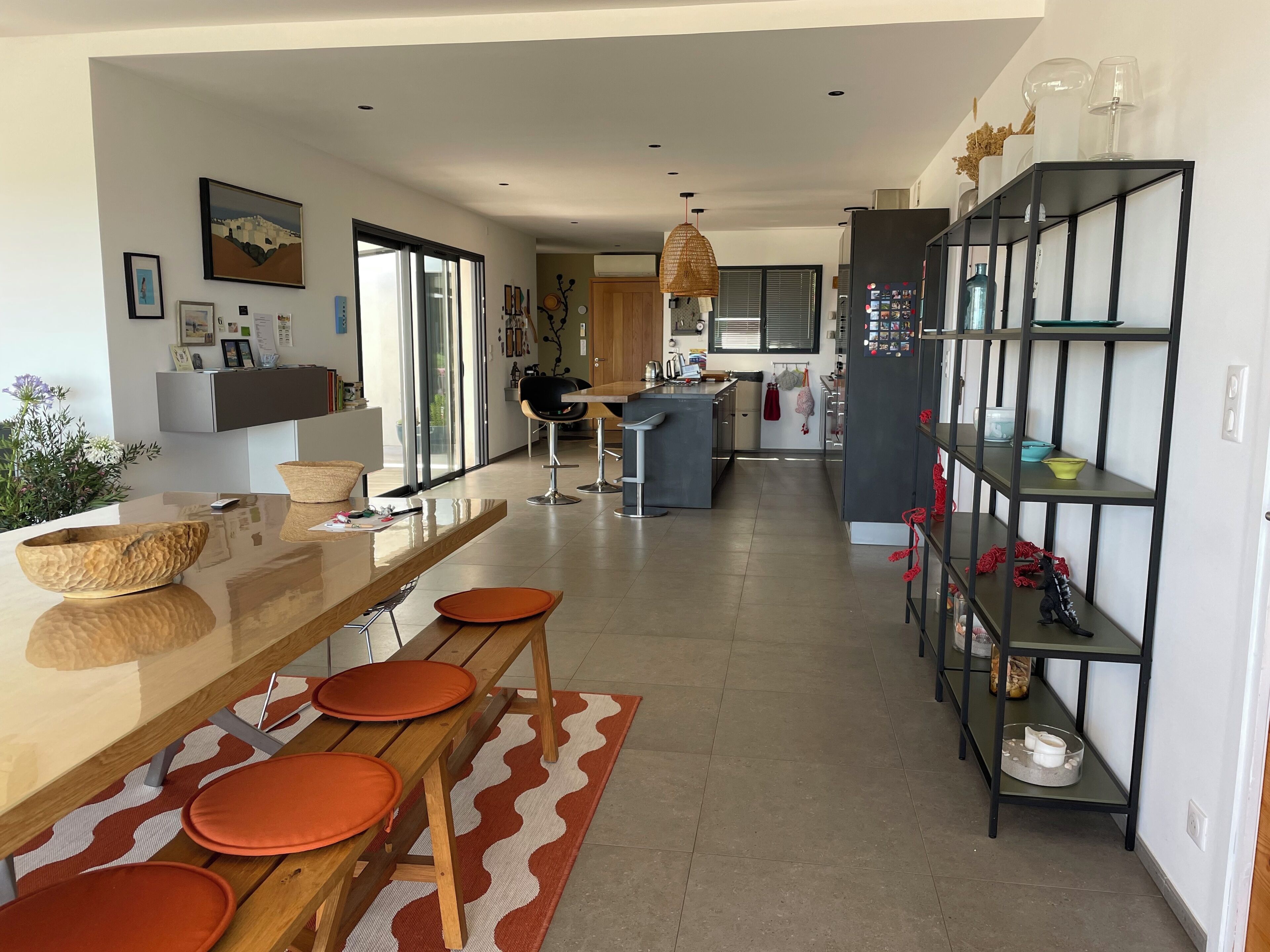 Une cuisine moderne dotée d’un îlot central, de tabourets de bar et d’un coin repas agrémenté d’un tapis à motifs.