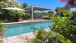 A swimming pool with a pergola and a wooden deck. - Beachfront family home for 14 people (Zonza)