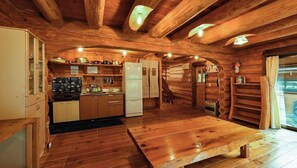 A wooden cabin interior with a kitchen, dining table, and a fireplace. - Maple House  Capacity 10 people With separate  / County Market Gifu (Gushi City)