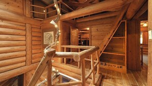 Un interior de madera con una escalera de caracol, paredes de madera y un cuadro enmarcado en la pared.