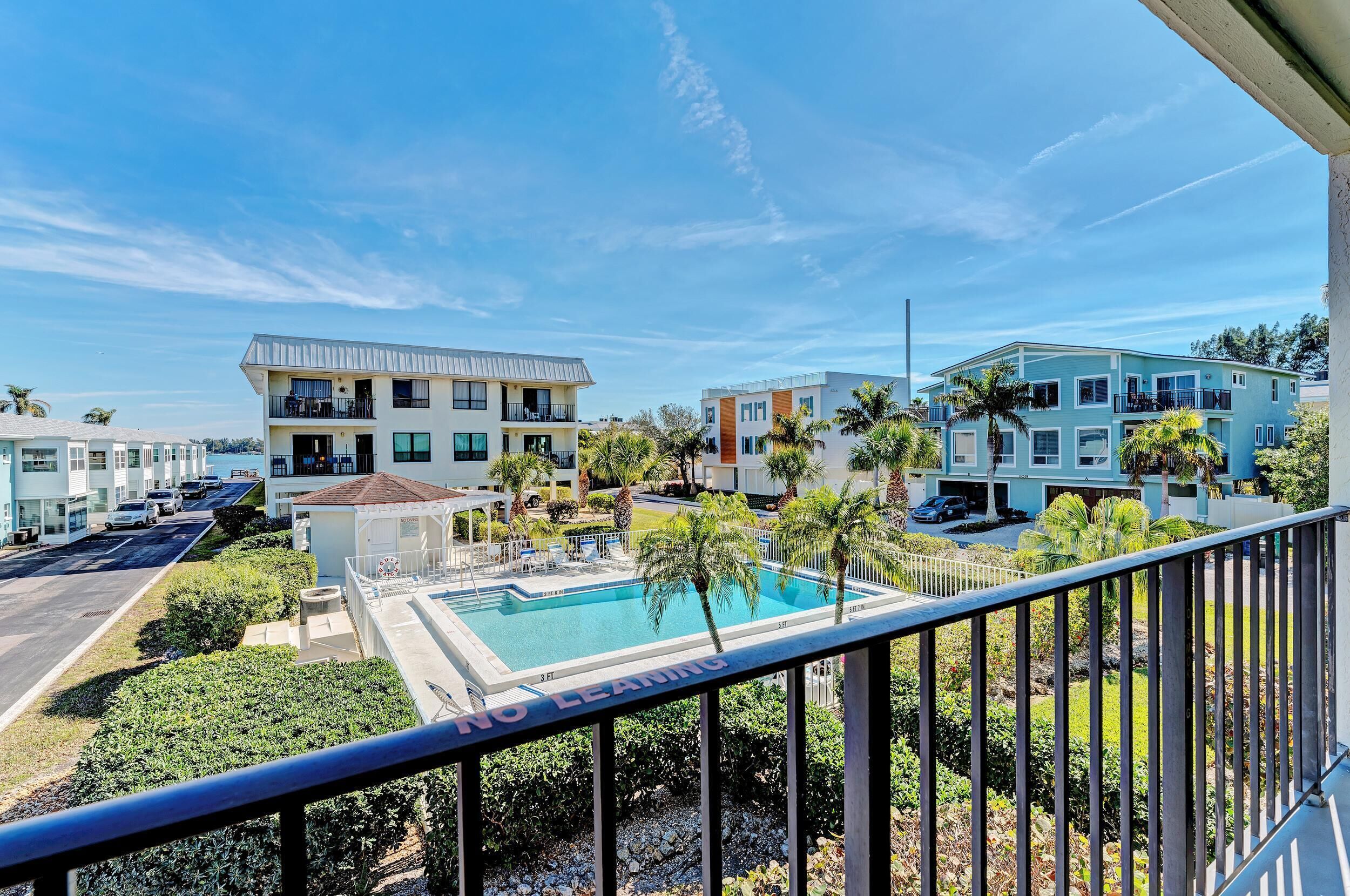 Zona residencial con edificios modernos, piscina y cielo despejado.