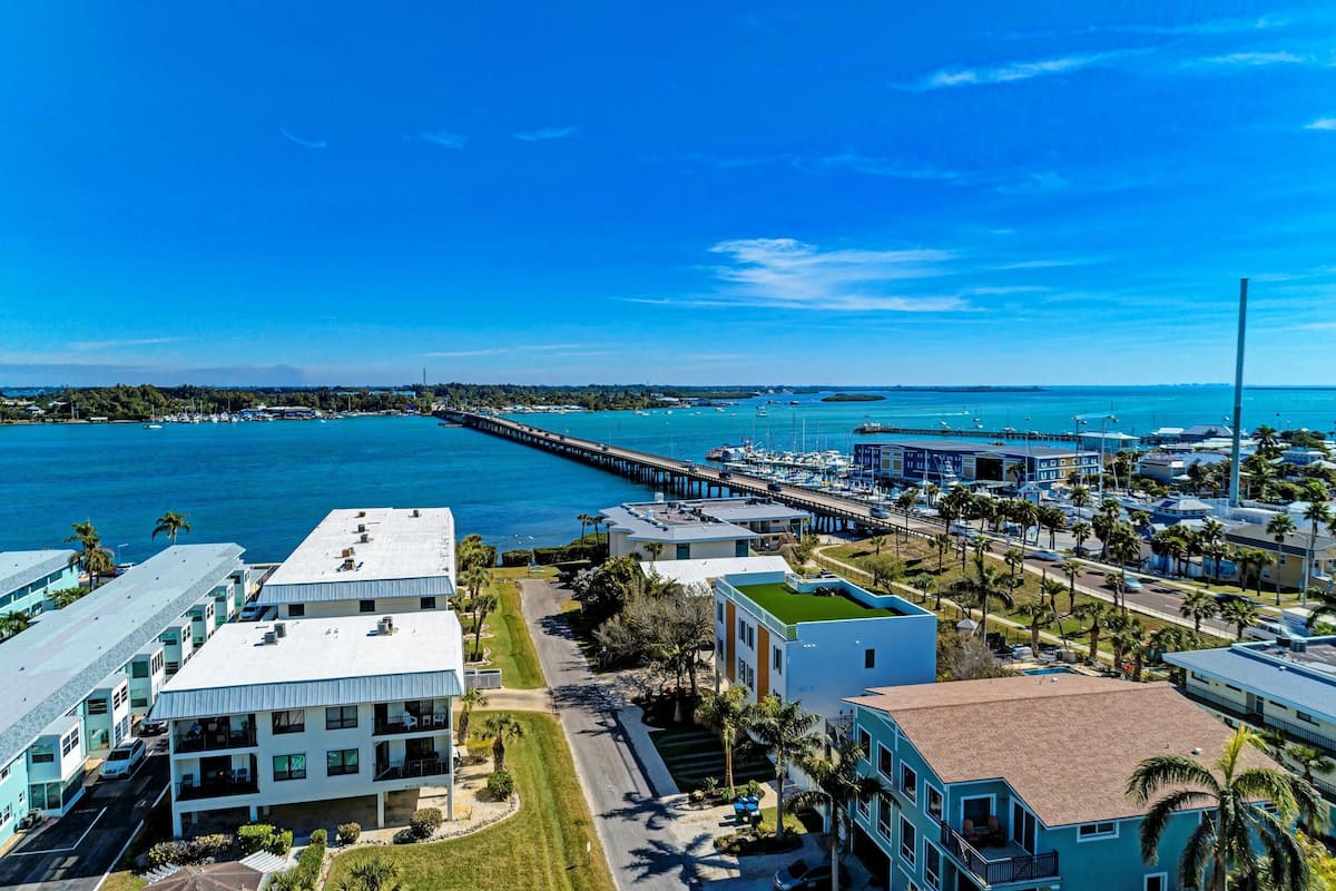 A coastal hotel with a view of the ocean and a pier extending into the water.