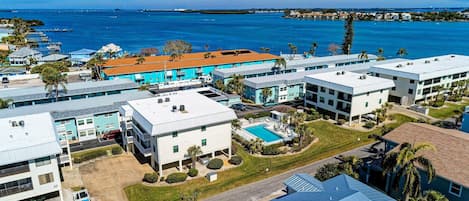 A coastal hotel with multiple buildings, a swimming pool, and a view of the ocean.