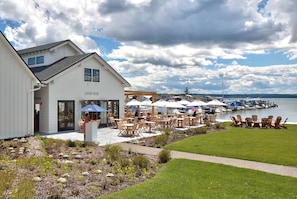A waterfront restaurant with outdoor seating and a view of the water. - Robust vacation home near wineries, nature and ski mountains in the FLX region! (Naples)