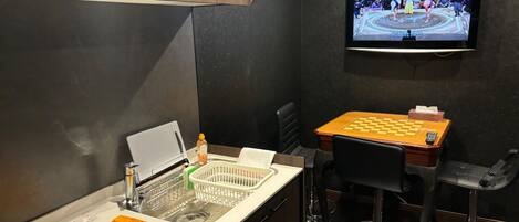 Een koelkast, een magnetron, een kookplaat, kookgerei, borden en bestek