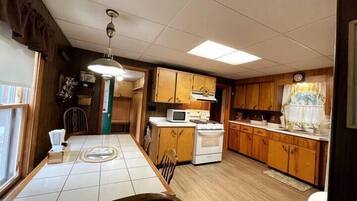 A kitchen with wooden cabinets, a microwave, and a stove.