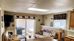 Een gezellige woonkamer met een bank, een houten salontafel en een televisie.