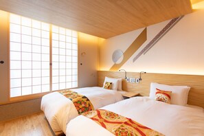 Habitación de hotel con dos camas, un ventanal grande y techo de madera.