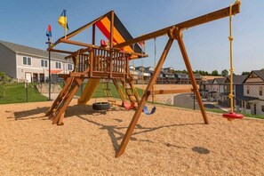 A playground with a swing set and a climbing structure. - Lakefront Rooftop Hangout Hot Tub Fire Pit Arcades (Branson)
