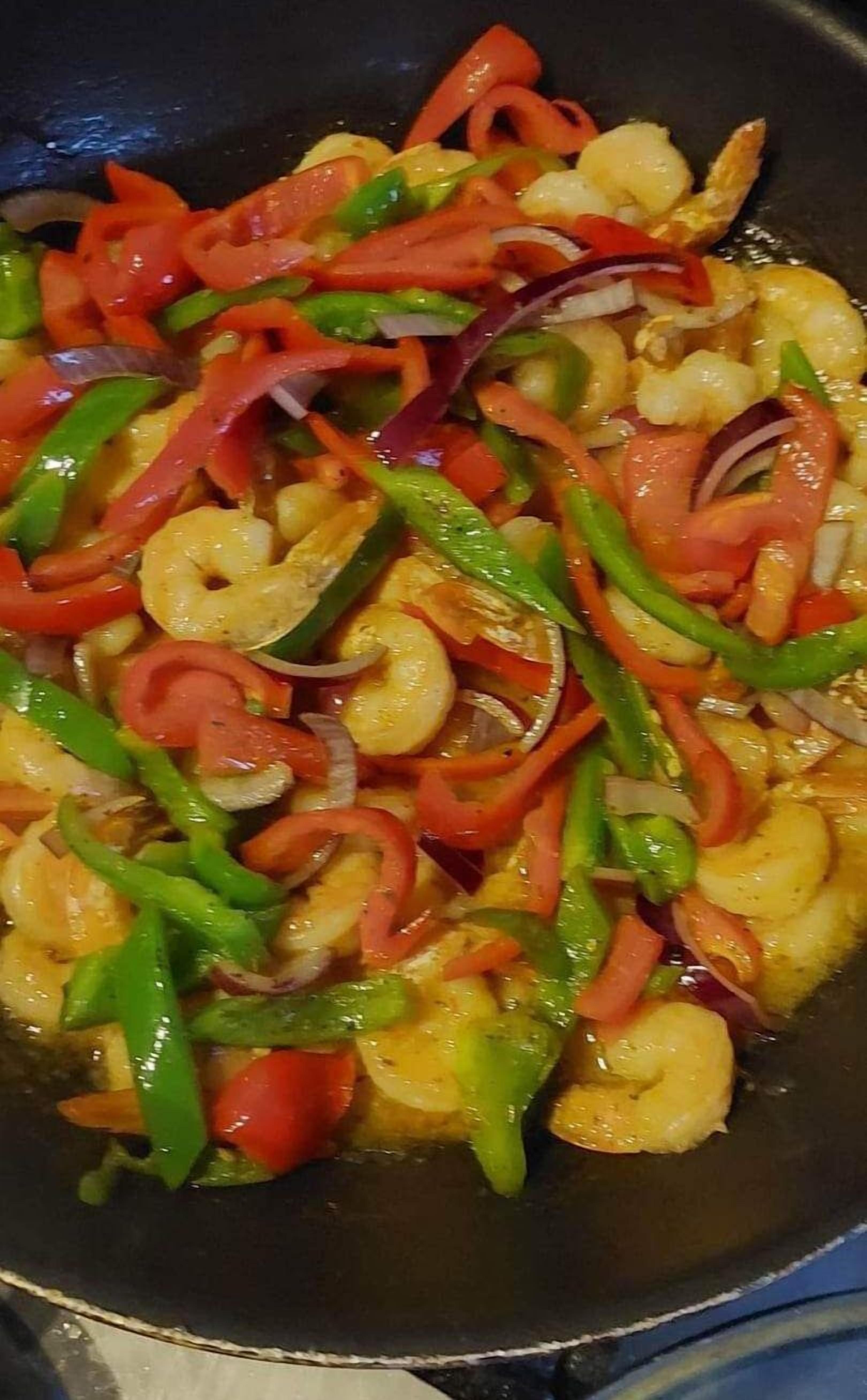 Un plat sauté composé de crevettes, de poivrons et d’oignons.