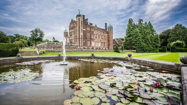 Un bâtiment historique doté d’une grande fontaine et d’un bassin orné de nénuphars.