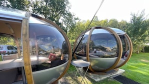 Deux capsules sphériques aux parois transparentes, chacune contenant un petit tabouret et un anneau métallique.