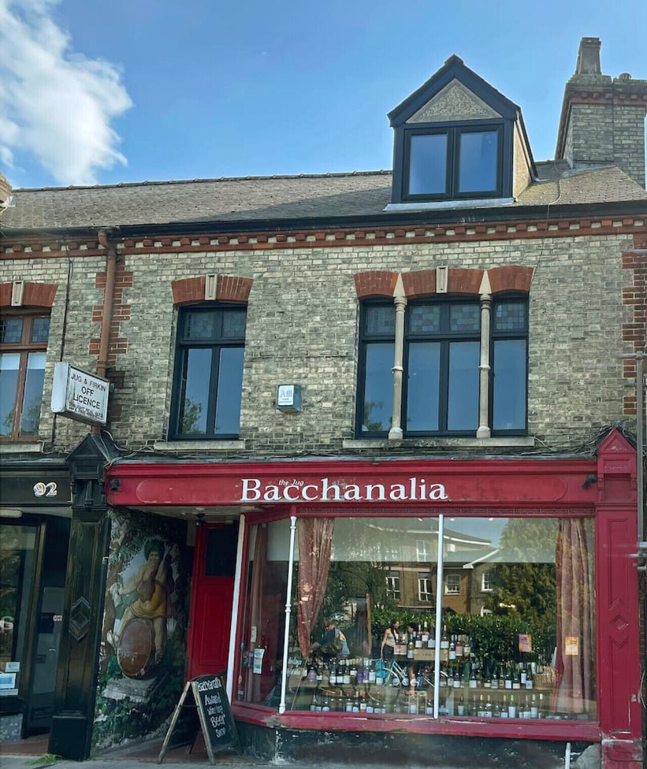 A building with a red awning labeled "Bacchanalia" and a large window display of bottles.