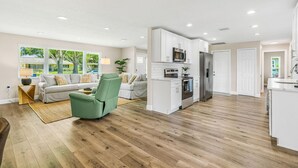 A modern kitchen with white cabinets, a microwave, and a refrigerator. - Heated Pool Hot tub Clearwater Dunedin Pet Friendly (Clearwater)