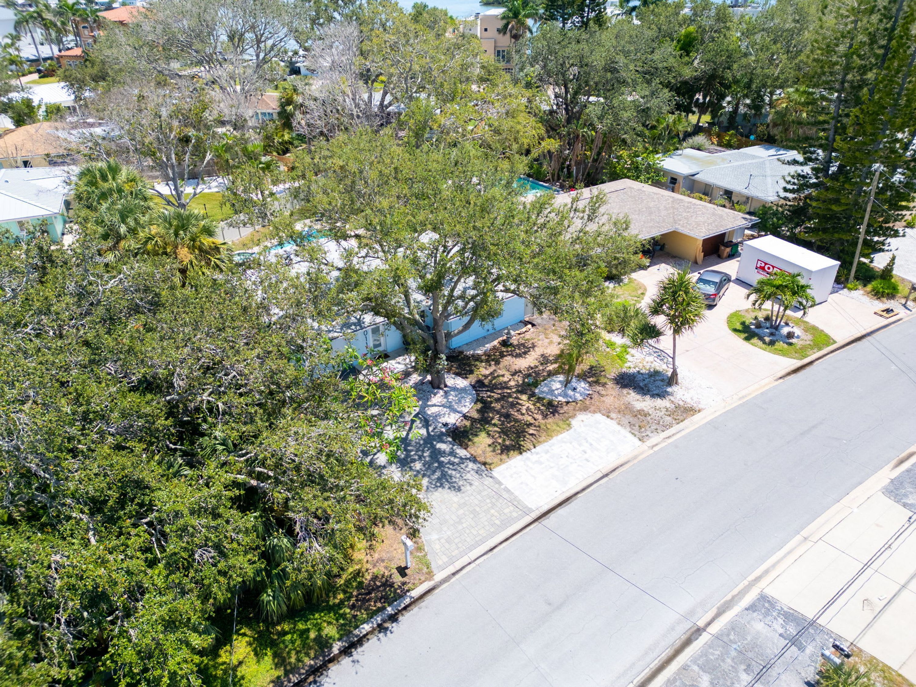 Vista aérea de una zona residencial con casas, árboles y una carretera despejada.