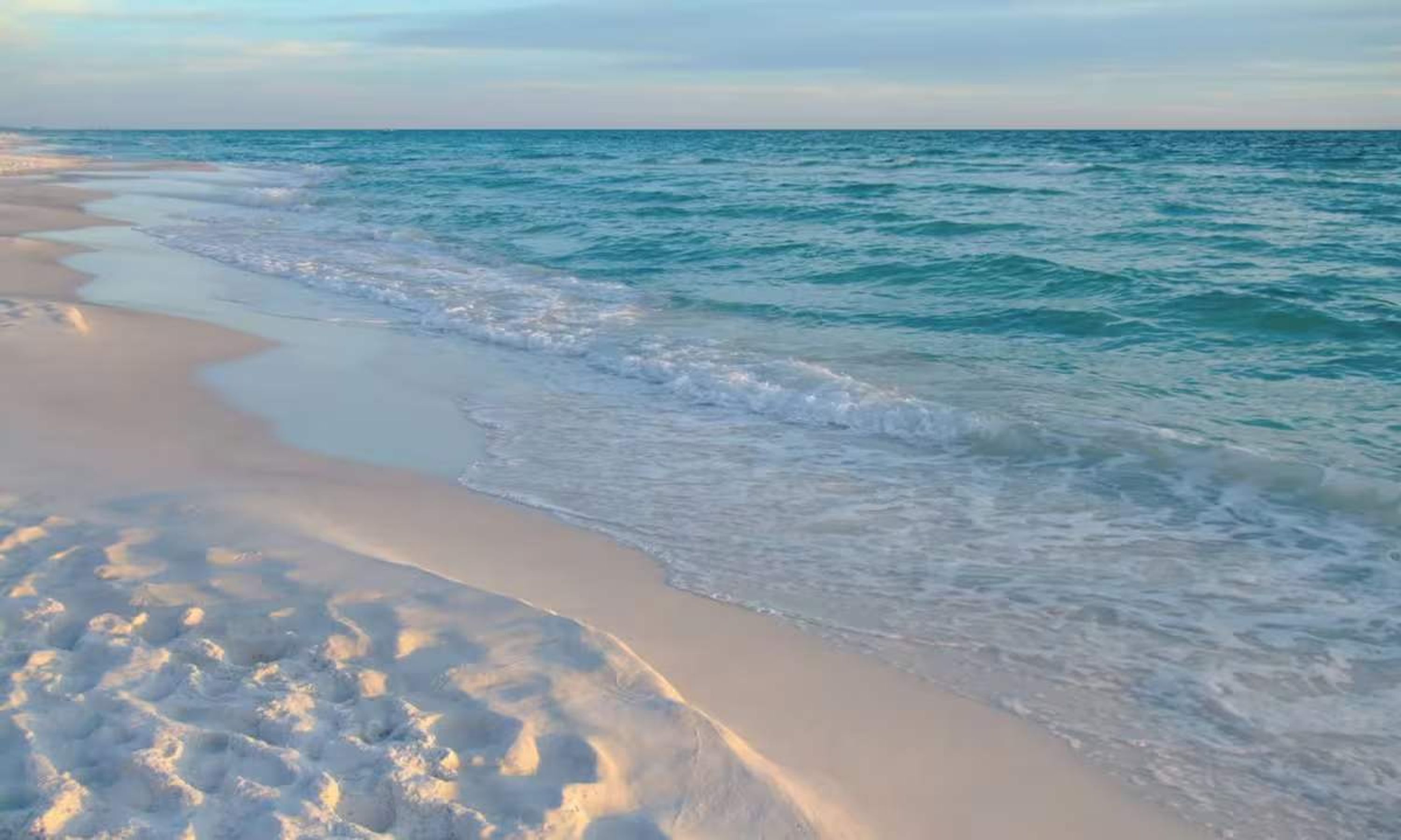Ein Strand mit sanft anschwellenden Wellen.