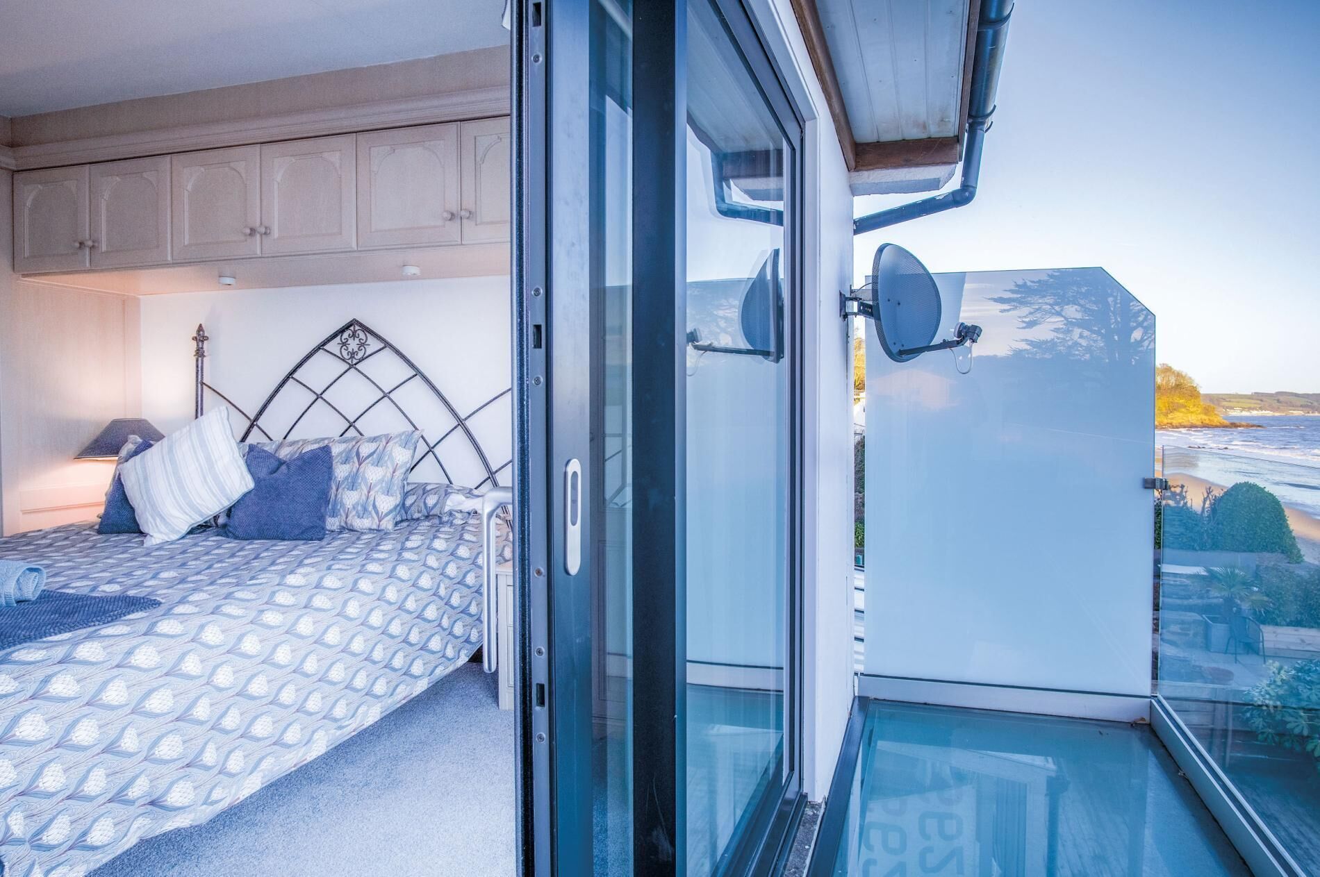 A bedroom with a bed, a nightstand, and a window overlooking a scenic view.