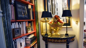 Une bibliothèque remplie de livres et une pancarte sur laquelle on peut lire : « Bonheur + Rentabilité + Incontournable ».
