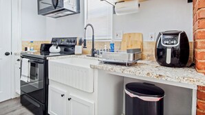 Una cocina compacta equipada con estufa, horno, microondas y cafetera.