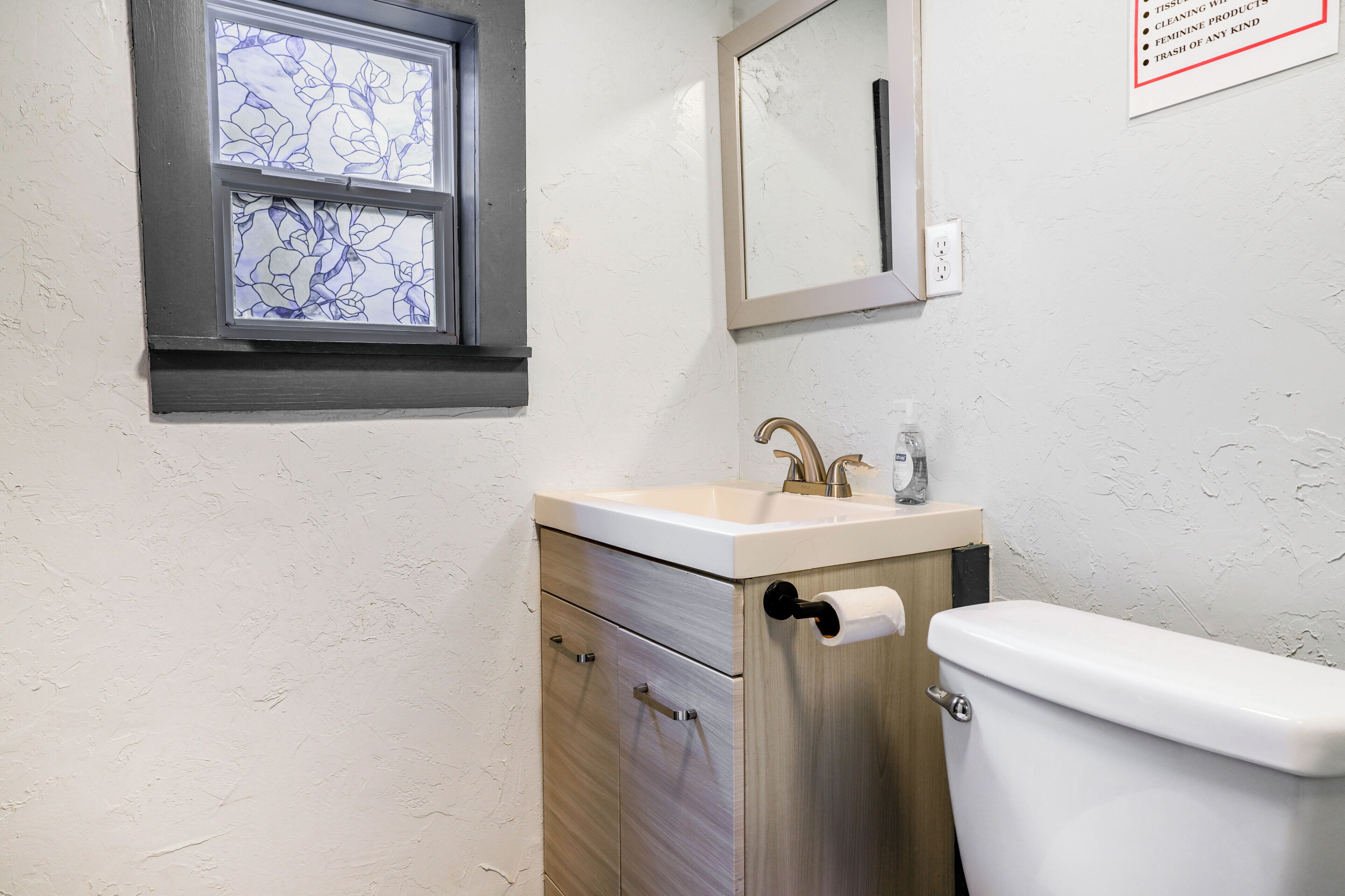 Ein Badezimmer mit Toilette, Waschbecken und Fenster.