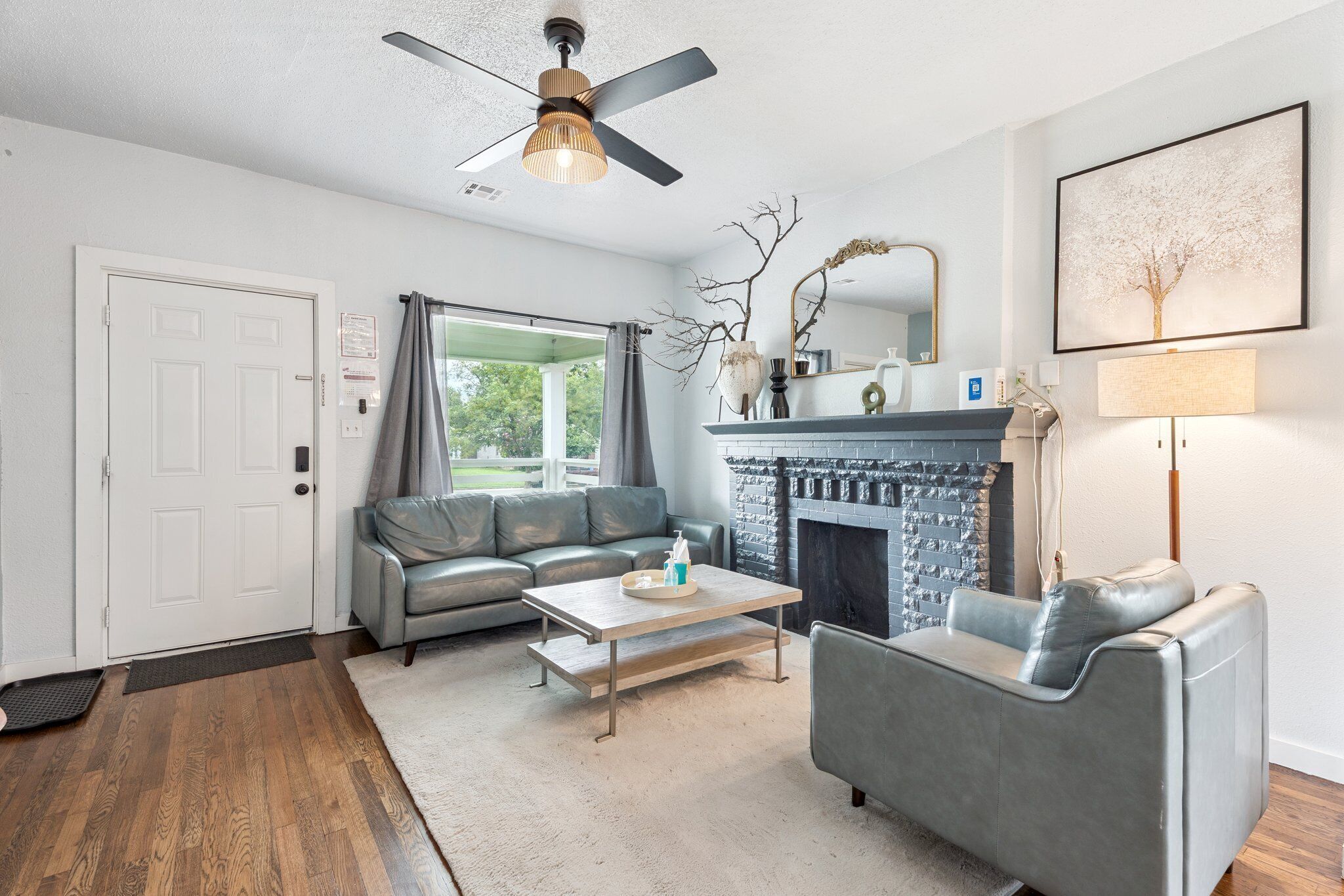 Step into a light-filled living room with large windows, sleek leather seating, and a cozy fireplace—perfect for lounging after a day of exploring OKC.