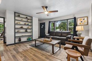 Ein modernes Wohnzimmer mit einer Couch, einem Couchtisch und einem Bücherregal.