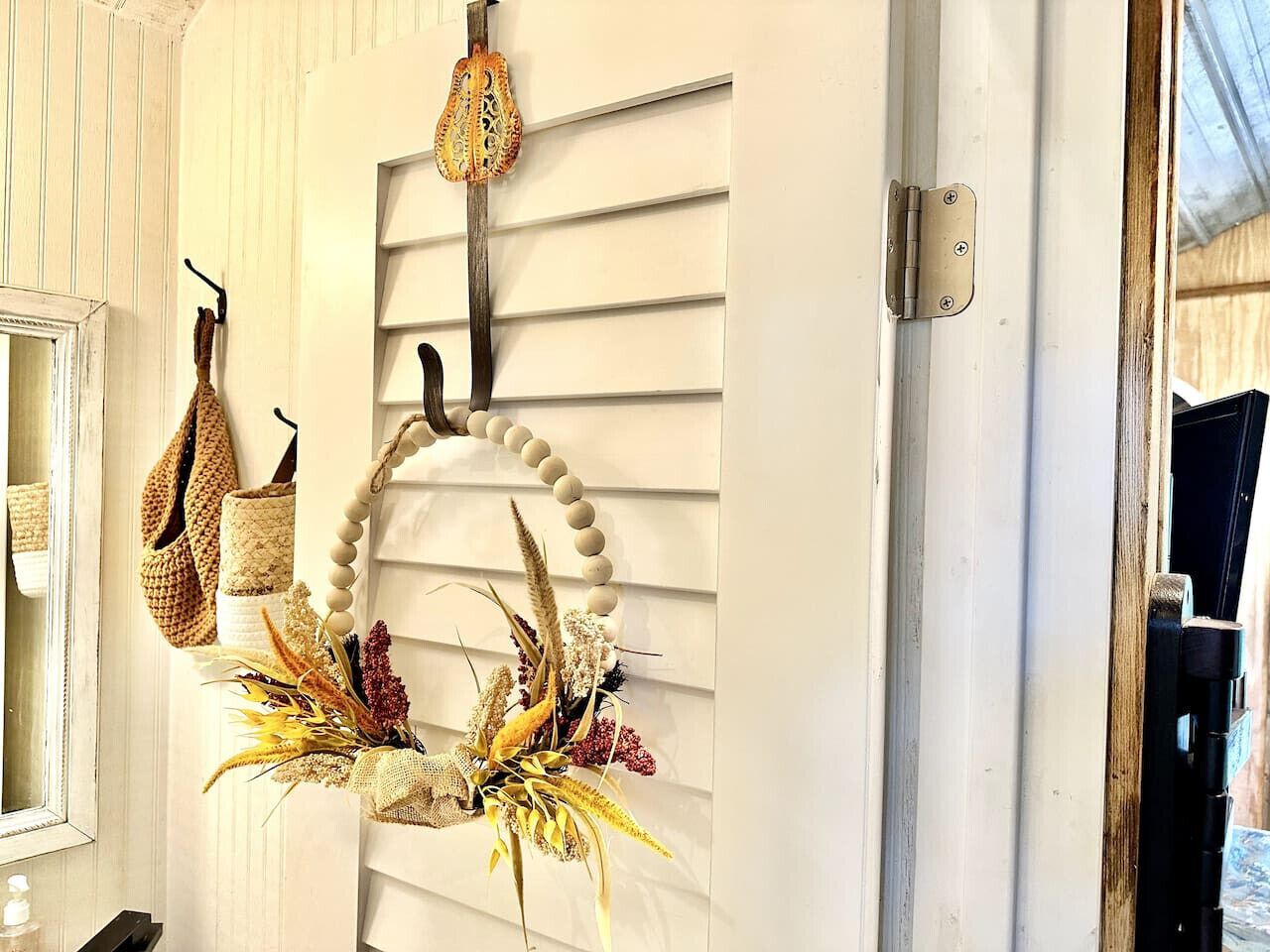 A door with a decorative wreath and a hanging bag.
