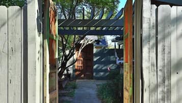 A wooden gate with a lantern above it, leading to a covered pathway.