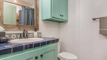 A bathroom with a sink, mirror, and toilet.