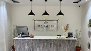 A reception desk with a sign reading "MAHAFALY HOTEL & RESORT MADAGASCAR" and a computer monitor. - Mahafaly Hotel & Resort (Antsirabe)
