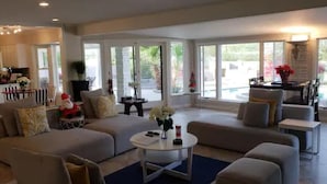 A spacious living room with a large sectional sofa, a coffee table, and a dining area with a table and chairs. - Wall Street Journal Featured-6 bath Lux Resort Home (Paradise Valley)