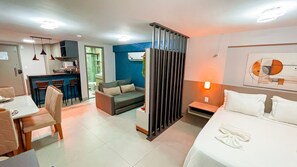 Une chambre d’hôtel moderne équipée d’un canapé, d’un coin repas, d’une cuisine et d’un lit.